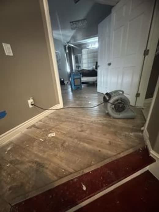 Flooring lifted to the subfloor, air mover set in the doorway